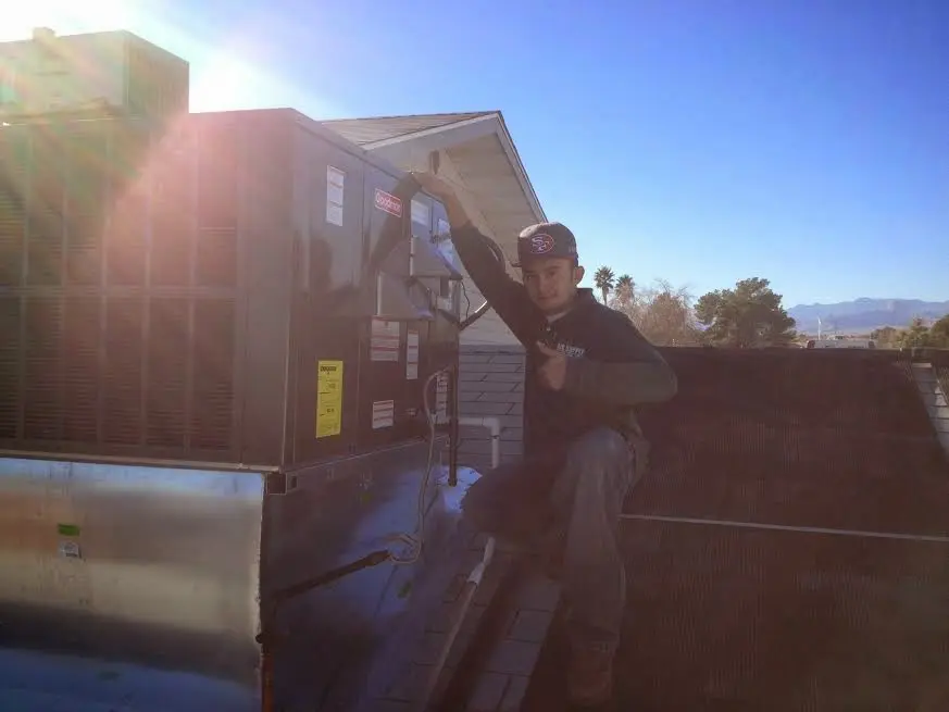 HVAC technician performing Heat Pump Repair on a rooftop unit in Eldorado at Santa Fe